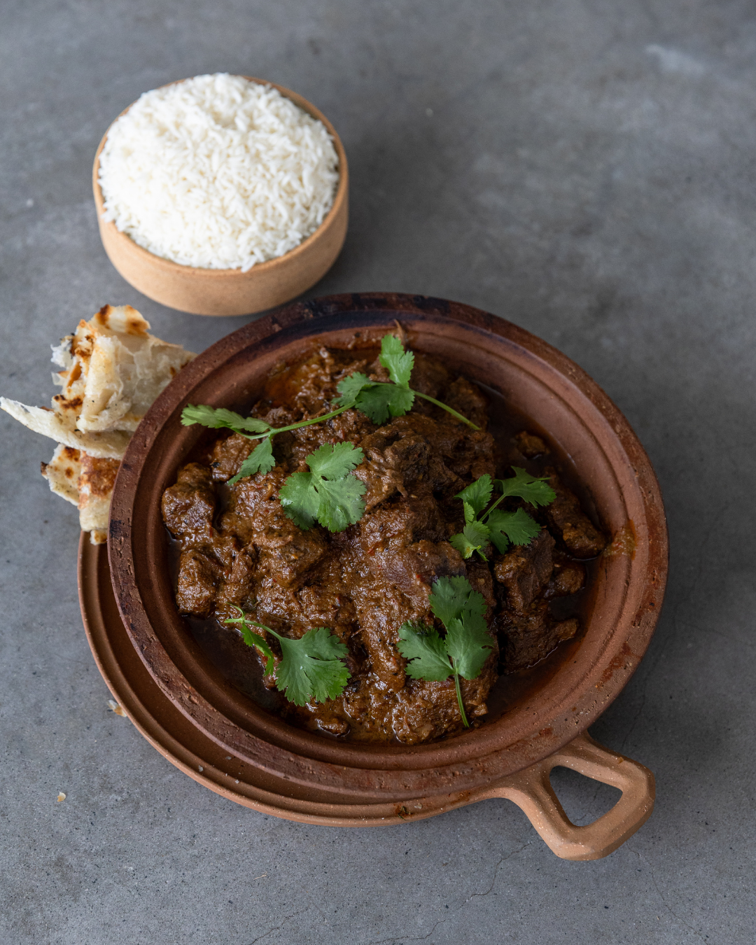 Rendang curry with goat served with rice and roti.