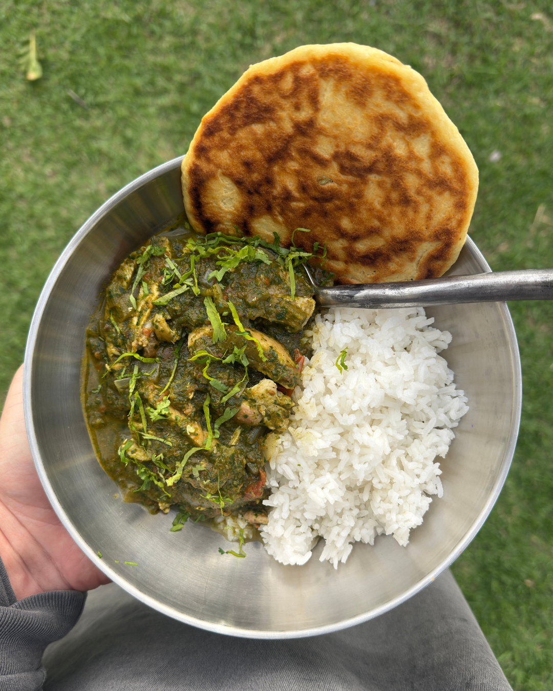 Chicken Saagwala in a bowl with rice and naan bread.